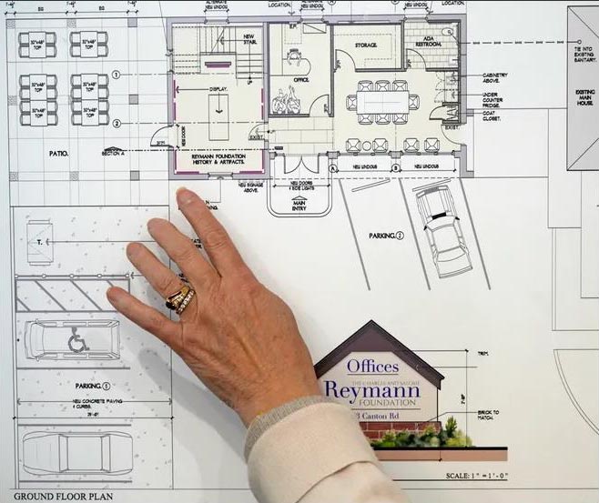 Margaret Reymann Skinner points to architectural plans to remodel a historic barn and garage.